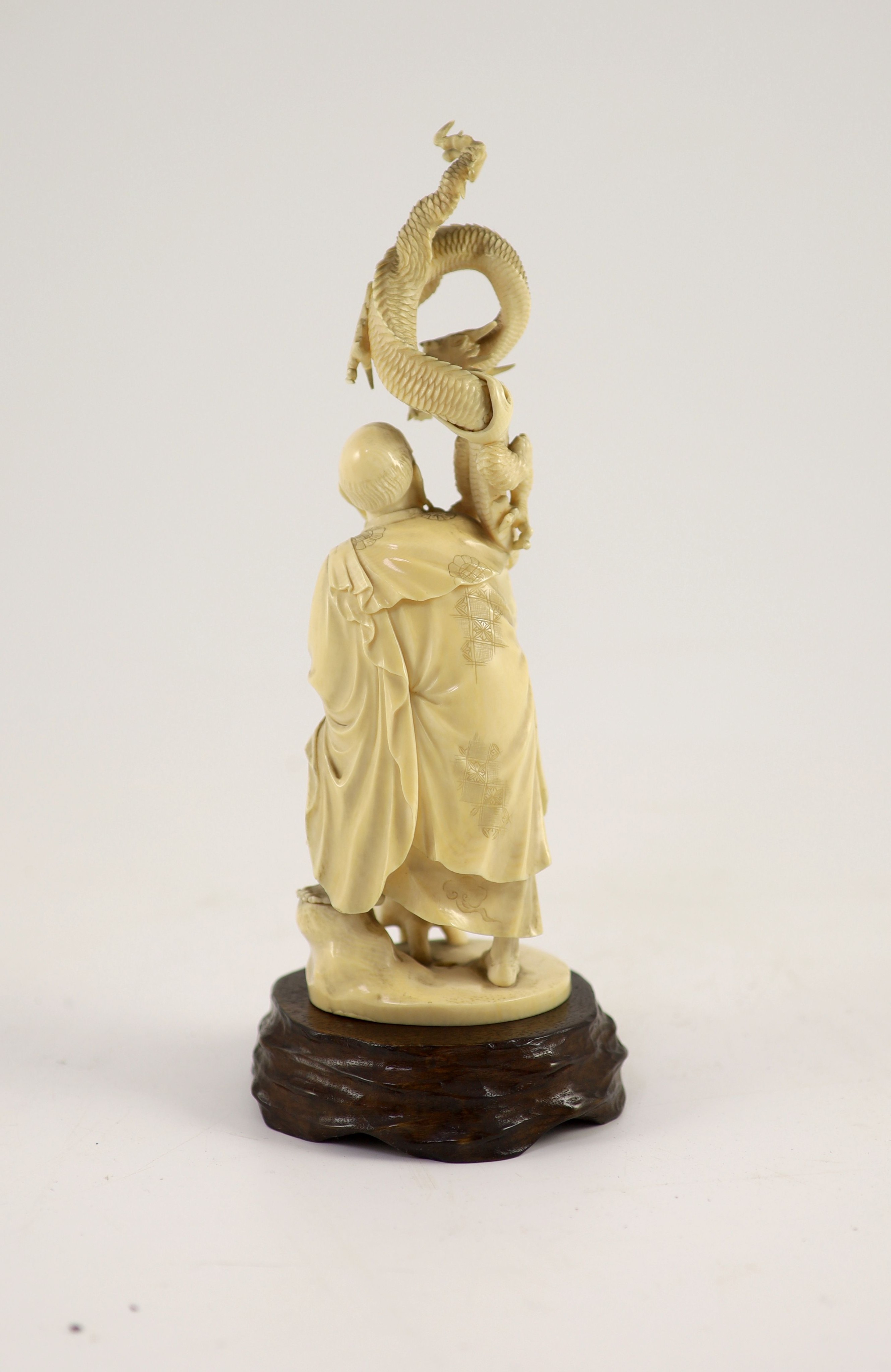 A Japanese ivory okimono of Handaka Sonja, Meiji period, signed Shozan, 22.5 cm high, wood stand